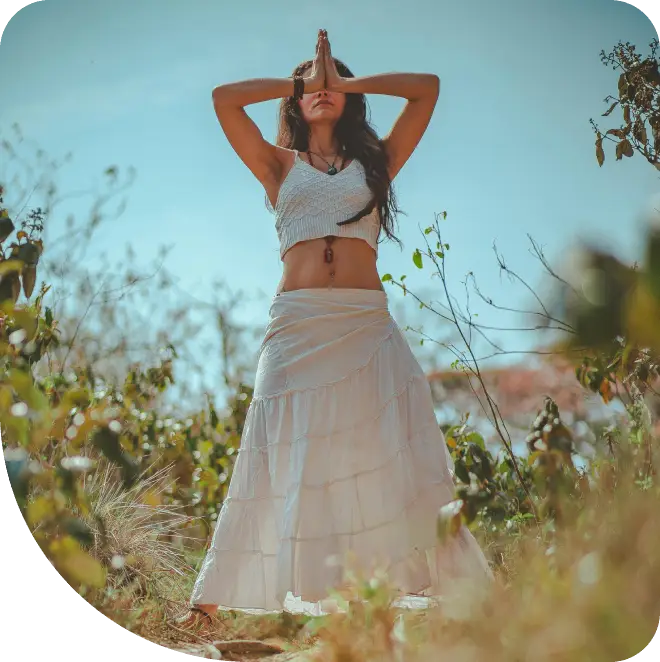 A woman in white dress standing on top of a hill.